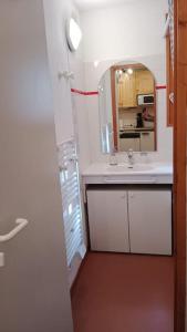 uma casa de banho com um lavatório e um espelho em Superbe appartement à Valfréjus em Valfréjus