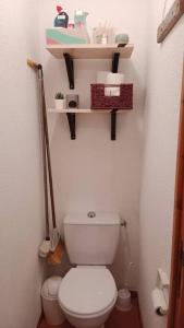 a bathroom with a toilet and shelves on the wall at Superbe appartement à Valfréjus in Valfréjus