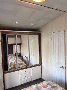 um quarto com uma cama e um espelho grande em Bird Lake Pastures em Great Billing