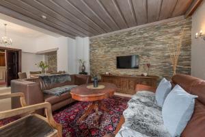 a living room with leather furniture and a brick wall at Hotel Rader in Bad Gastein