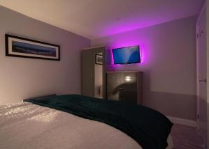 a bedroom with a bed with a purple lighting at Stay Indigo in Ballycastle