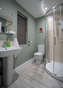 a bathroom with a sink and a toilet and a shower at Stay Indigo in Ballycastle