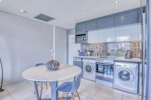 a kitchen with a table and two washing machines at 1 bed Luxury Apartment with pool in Johannesburg