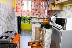 een kleine keuken met een fornuis en een magnetron bij EP Home in Meru