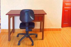 una sedia nera seduta su una scrivania di legno di EP Home a Meru