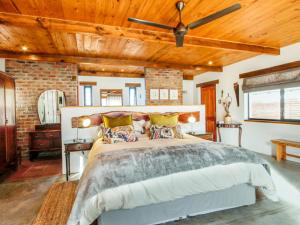 a bedroom with a large bed with a wooden ceiling at Duikersdrift Winelands Country Escape in Tulbagh