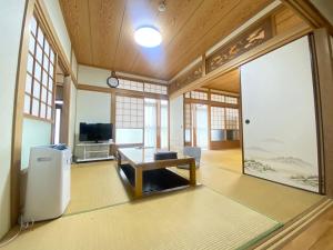 a living room with a table and a tv at 島の宿　結んちゅ in Amami