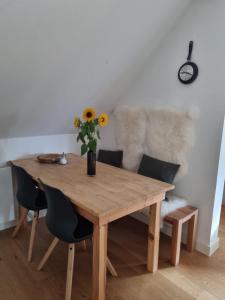 une table en bois avec des chaises et un vase de fleurs. dans l'établissement Rurstübchen, à Simmerath