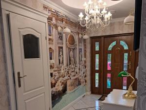 a hallway with a chandelier and a wall mural at Noclegi "LAS WYPAS" 2 Domki drewniane całoroczne, oraz 1 Apartament dla dwojga - wynajem in Trzcianka