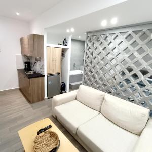 uma sala de estar com um sofá branco e uma cozinha em Navarino Jacuzzi Studio RT Hospitality Services em Tessalônica