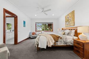 a white bedroom with a bed and a mirror at 10BR Great Ocean farmstay for 20 people in Leopold