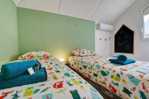 um quarto com 2 camas e toalhas em NYLA Mango em Saint-Paul