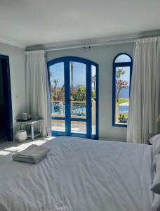 1 dormitorio con 1 cama grande y 2 ventanas en Ras Katy Sunset Views en Sharm El Sheikh