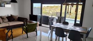 een woonkamer met een tafel, stoelen en een bank bij Apartman Retro with heated pool and gym for 8 in Murter