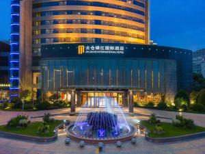 a large building with a fountain in front of it at Jin Jiang International Hotel Taicang in Taicang