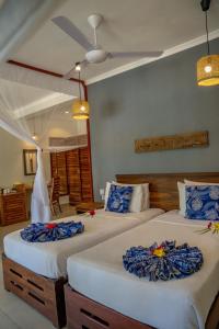 1 Schlafzimmer mit 2 Betten in Blau und Weiß in der Unterkunft Michamvi Sunset Bay in Michamvi