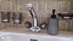 un lavandino in bagno con rubinetto e spazzola di Le Charlot a Saas-Grund