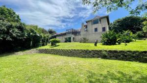 une maison sur une colline avec une cour herbeuse dans l'établissement 27 @ Wozani Ridge, à Hibberdene