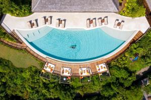 an overhead view of a swimming pool with chairs and water at Six Senses Yao Noi in Ko Yao Noi