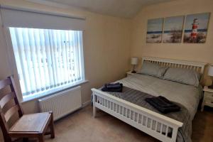 a bedroom with a bed with two bags on it at Two bedroom character cottage in Rhuddlan