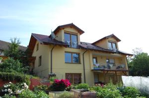 ein gelbes Haus mit Balkon und einigen Blumen in der Unterkunft Ferienwohnung Grosso in Gräfendorf