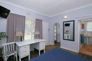 ein Heimbüro mit einem Schreibtisch und einem Spiegel in der Unterkunft Sun Garden Cottage in Johannesburg