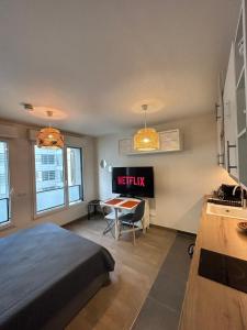 a bedroom with a bed and a desk and a kitchen at Studio Design & Cosy avec Parking in Issy-les-Moulineaux
