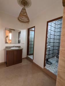 a bathroom with a sink and a large mirror at darna surf house anza in Agadir