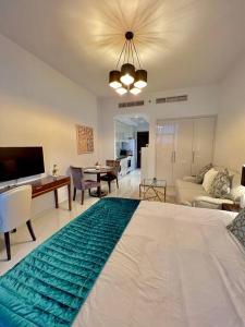 Un dormitorio con una cama grande y una sala de estar. en Ghalia Damac Studio Apartment, en Dubái