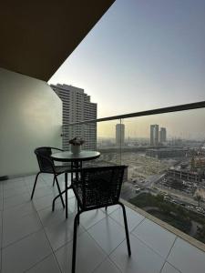 Una mesa y sillas en un balcón con vista a una ciudad. en Ghalia Damac Studio Apartment, en Dubái