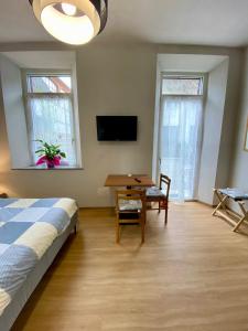 a bedroom with a bed and a table and a tv at Notte di Note - home hospitality in Busto Arsizio