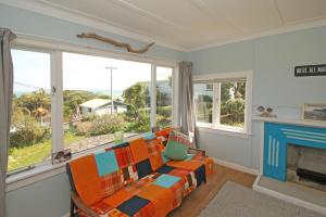a living room with a couch and a fireplace at Classic bach near the beach in Oneroa