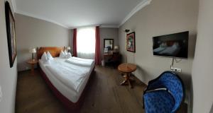 um quarto de hotel com uma cama e uma cadeira em Hotel Goldene Sonne em Landshut