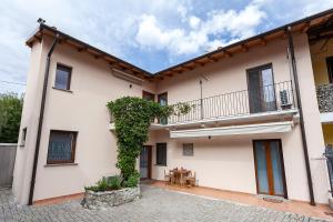 een wit huis met een balkon en een tafel bij Veruskacamere Camera 3 in Somma Lombardo