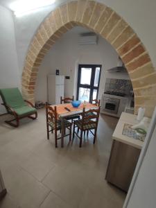 a kitchen and dining room with a table and chairs at Appartamenti Poseidon in Marsala