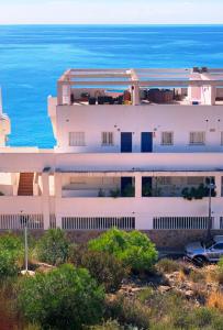 a white building with the ocean in the background at Holiday Home Benidorm with sea views, roof terrace and swimming pool in Benidorm