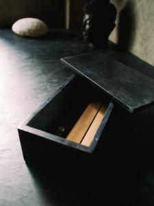 Una caja negra con un trozo de madera. en SURFLAB VILLA, en Balian