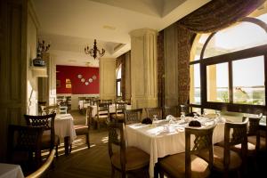 a restaurant with white tables and chairs and a window at Holy Family Hotel in Jabal aţ Ţayr