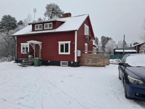 a red house with a car parked in front of it at Mattmar vila 