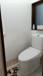 a bathroom with a white toilet and a mirror at シェアハウスの和室7畳or洋室 24時間スーパー徒歩5分 共同ワークスペース有 