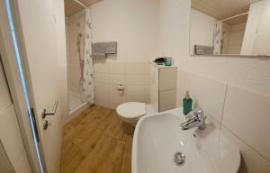 ein weißes Badezimmer mit Waschbecken und Toilette in der Unterkunft MBar in Altnau