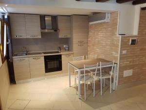 a kitchen with a table and chairs in a room at Venezia Holiday in Chioggia +11 photos