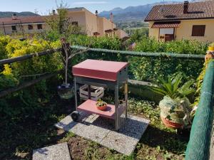 una mesa rosa y roja en la parte superior de un jardín en Villetta La Pigna, en Castel di Sangro
