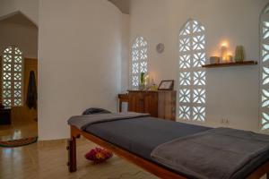 a bedroom with a bed and two arched windows at Michamvi Sunset Bay in Michamvi