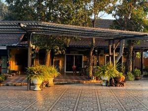 un pavillon avec des plantes en pot devant un bâtiment dans l'établissement บ้านพักสิริ มุกดาหาร (Baan Siri Mukdahan), à Ban Muang Ba