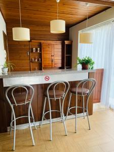 a kitchen with three bar stools at a counter at Forest fairy tale in Bansko