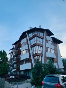 a tall building with a car parked in front of it at Forest fairy tale in Bansko