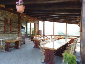 a restaurant with wooden tables and chairs and windows at Transylvanian Views in Peştera