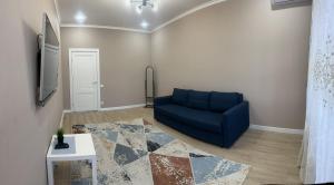 a living room with a blue couch and a table at park home uralsk in Oral