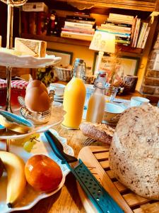 a table with bread and eggs and bottles of orange juice at La Remise - Les Chambres in Neufchâteau